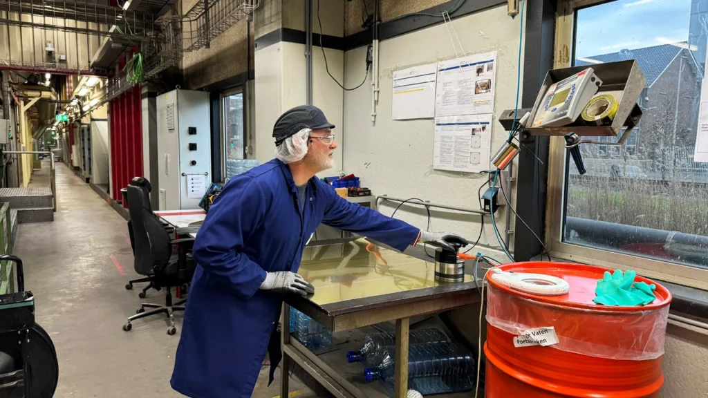 A lacquer layer thickness measurement at a workstation beside a FrieslandCampina production line.