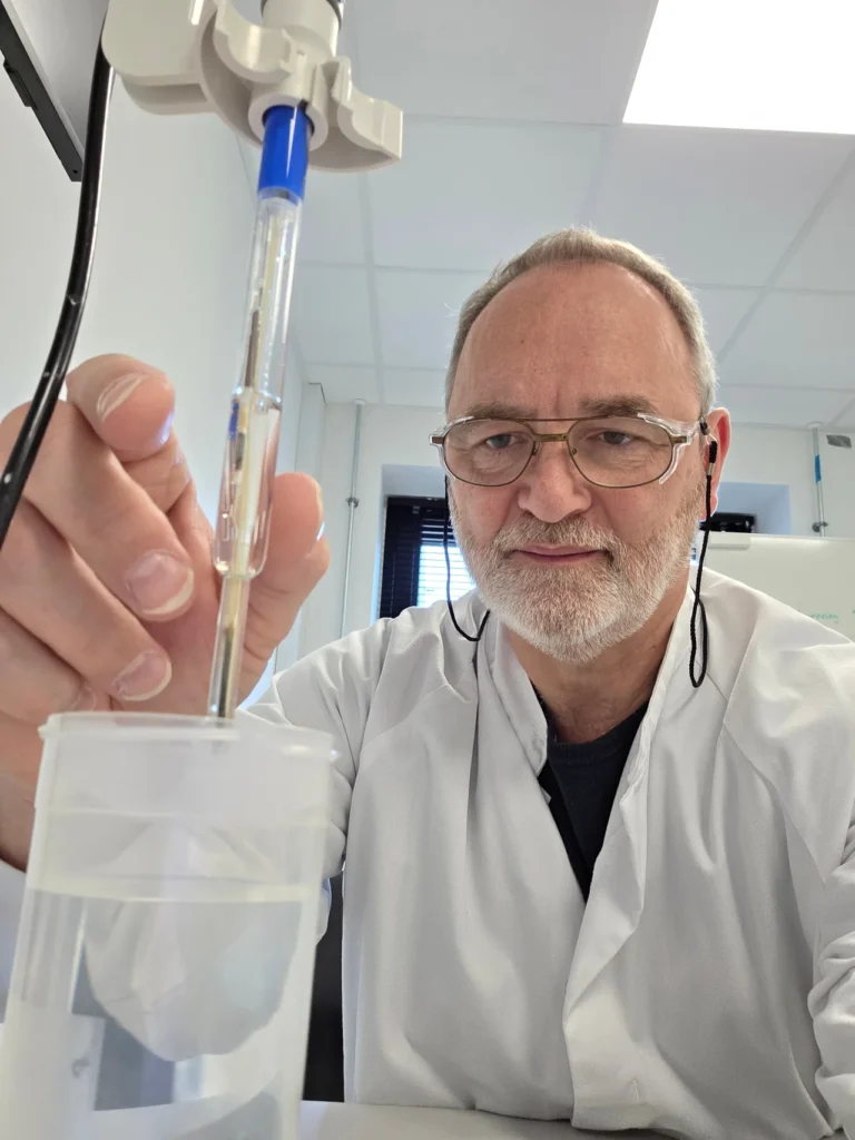 A pH electrode held in a beaker during a flush water measurement at Palsgaard.