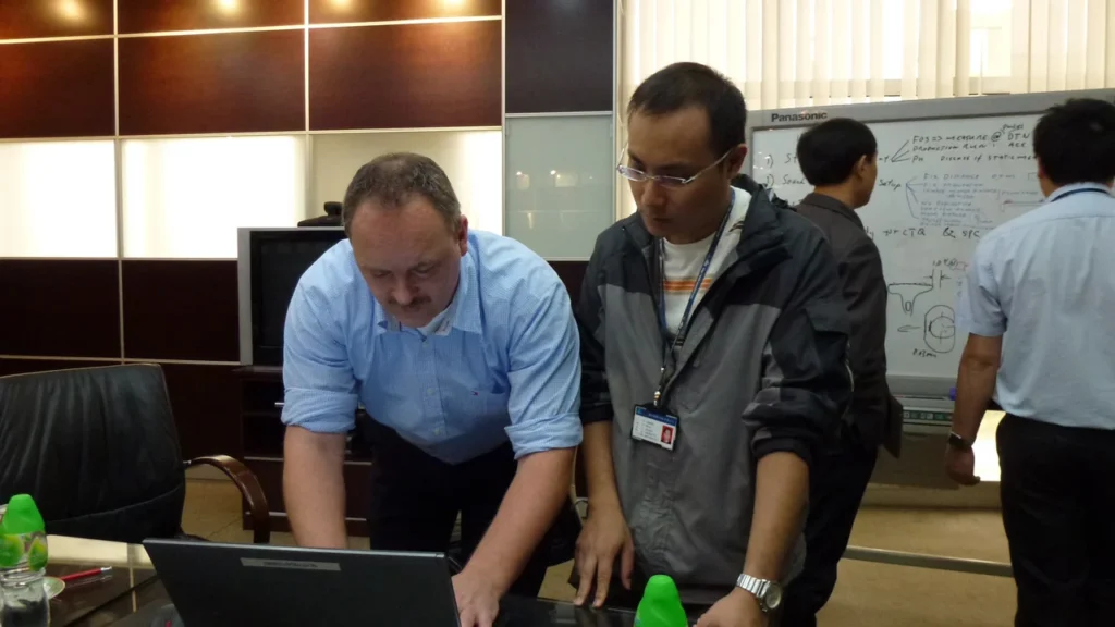 A discussion around a laptop during a supplier visit in Asia for Philips.